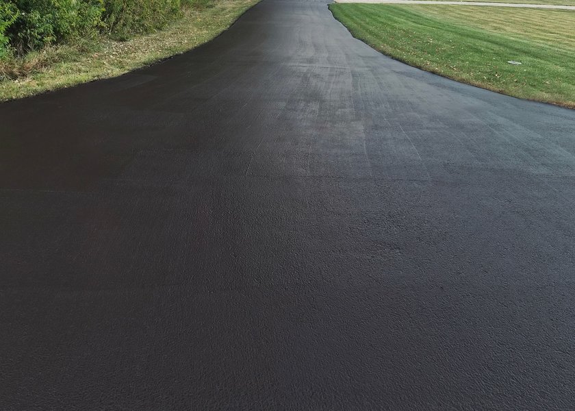 wide driveway apron with fresh blacktop finish