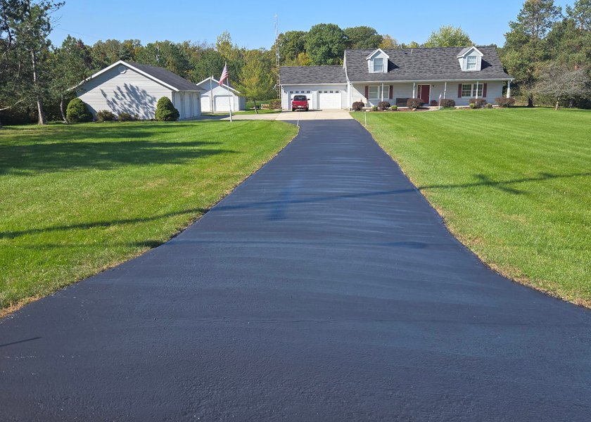long driveway leading to a home after sealcoating