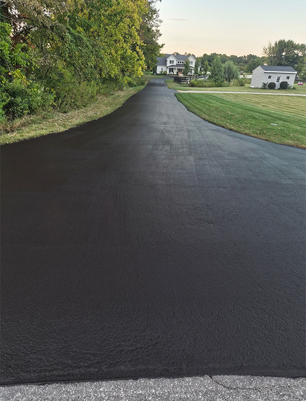 wide driveway apron with fresh blacktop finish