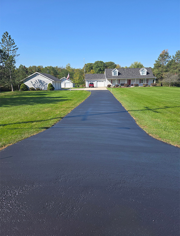 long driveway leading to a home after sealcoating